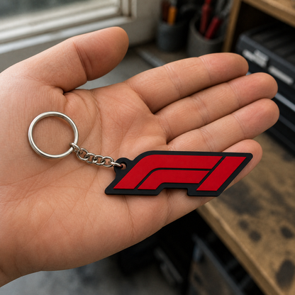 Red and black motorsport emblem keychain resting naturally on an open palm